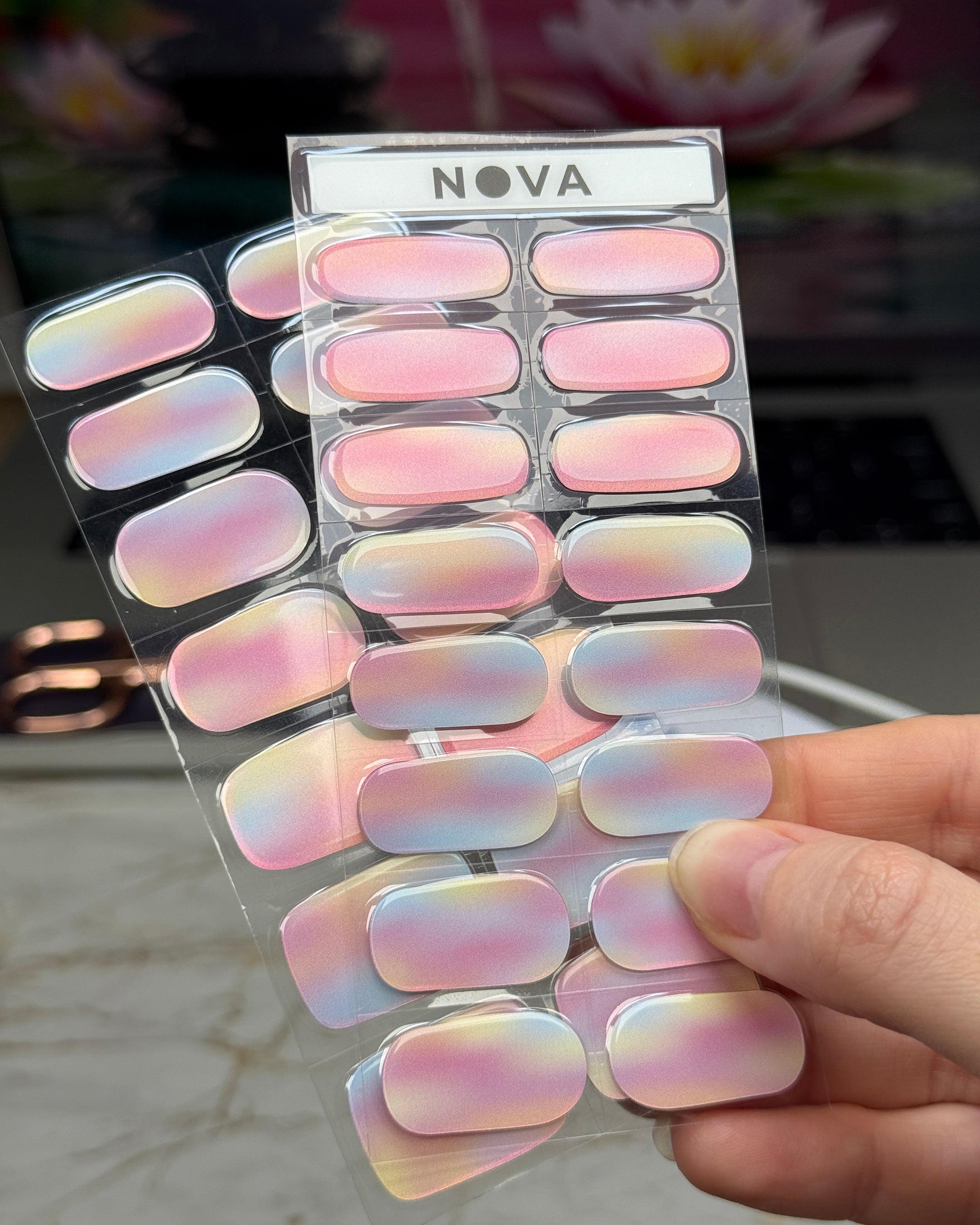 Sticker sheet display of semicured gel stickers with watercolor gradient design featuring shades of pink, blue, and yellow with a shimmer finish.