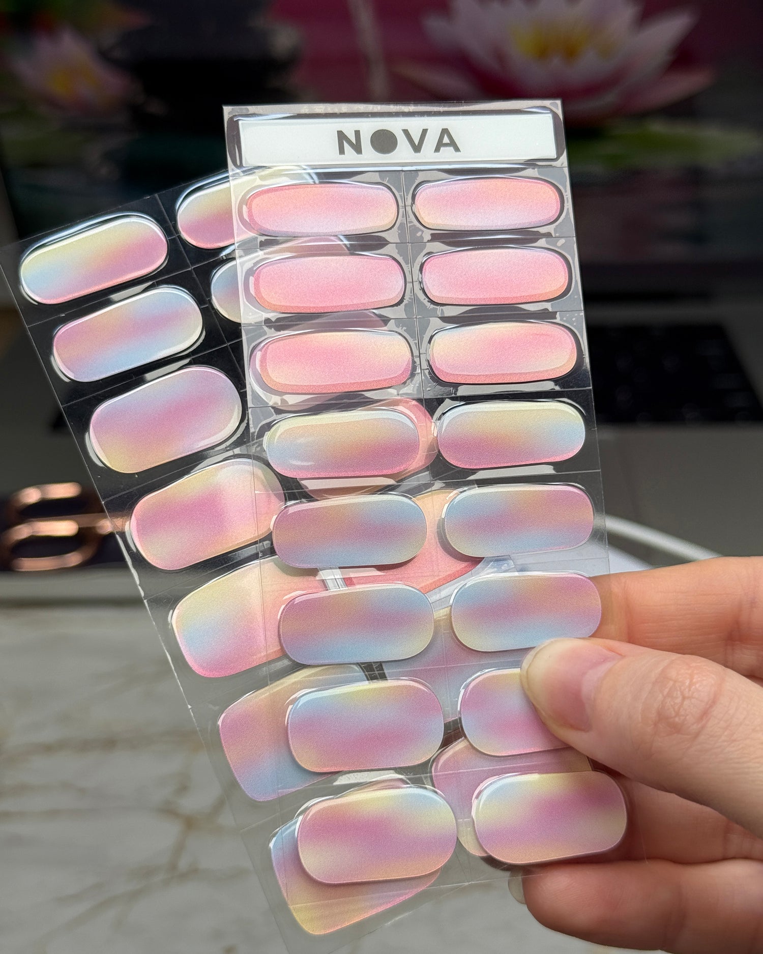 Sticker sheet display of semicured gel stickers with watercolor gradient design featuring shades of pink, blue, and yellow with a shimmer finish.